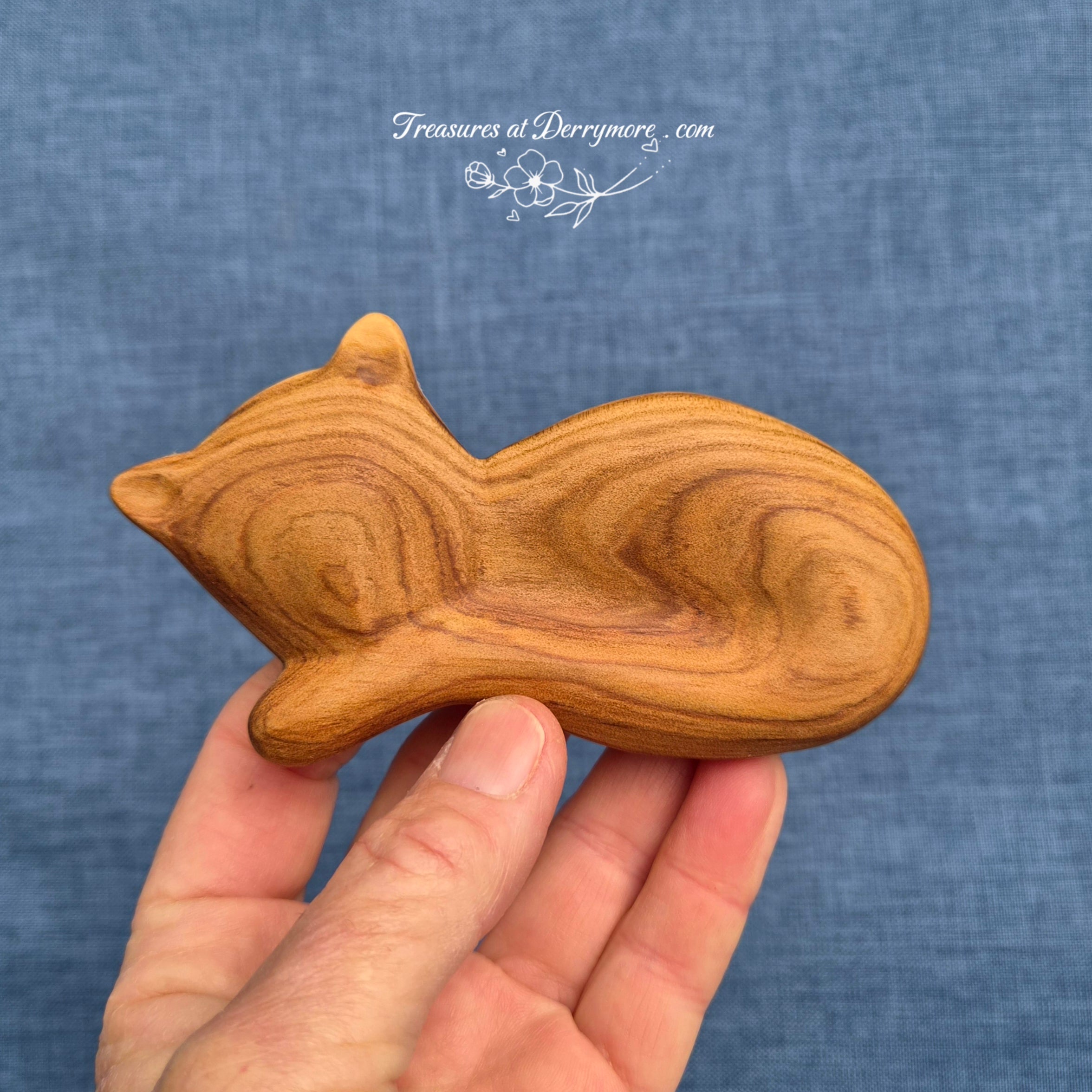 Hand carved wooden comfort piece shaped like a cat. Held in the hand