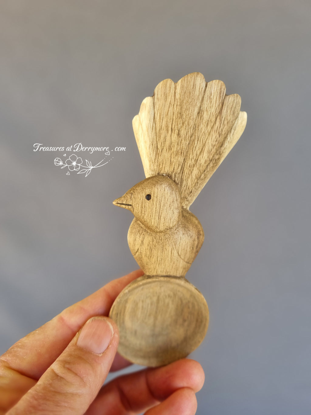 Hand carved Williewagtail spoon held in the hand