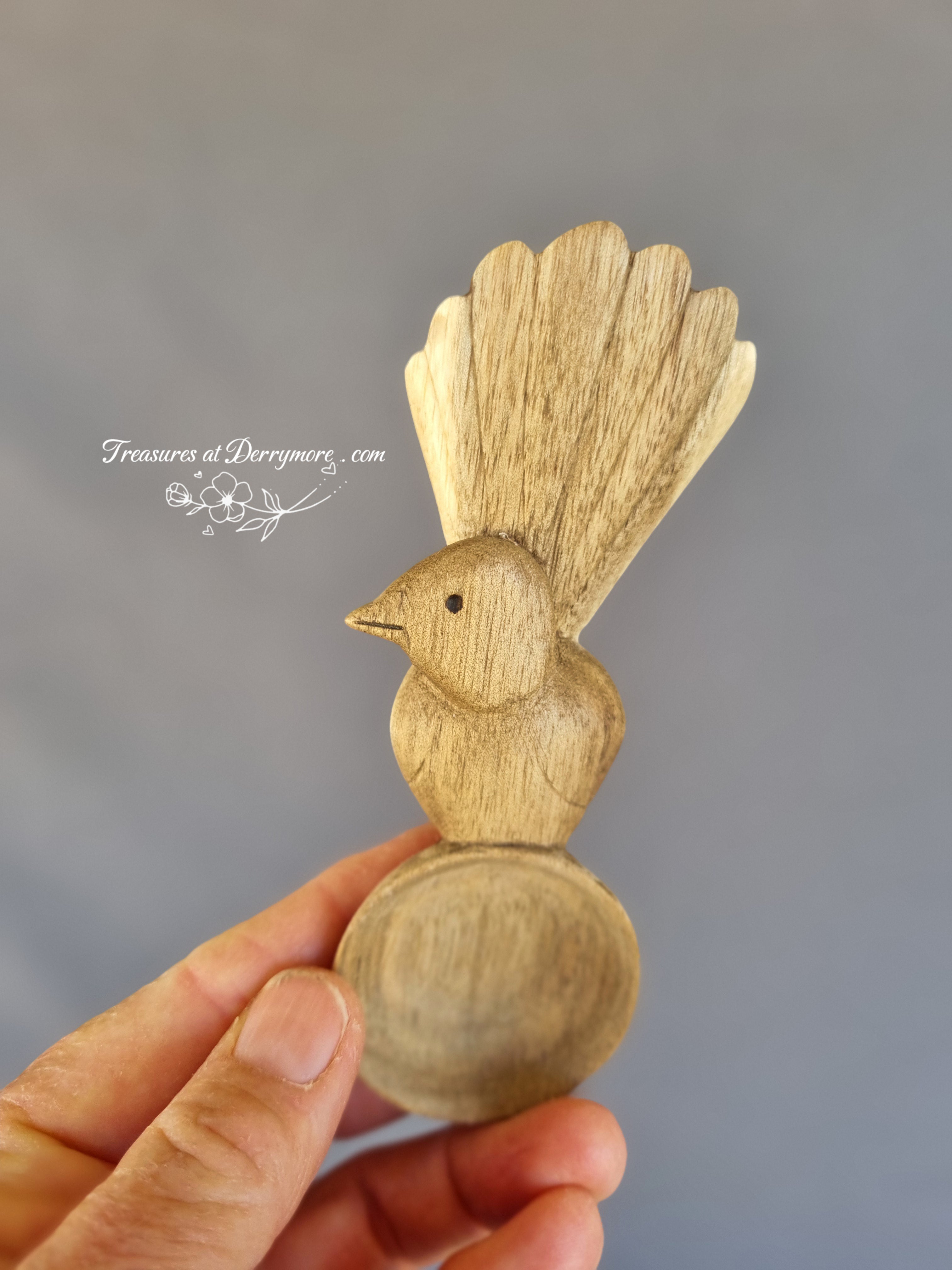 Hand carved Williewagtail spoon held in the hand