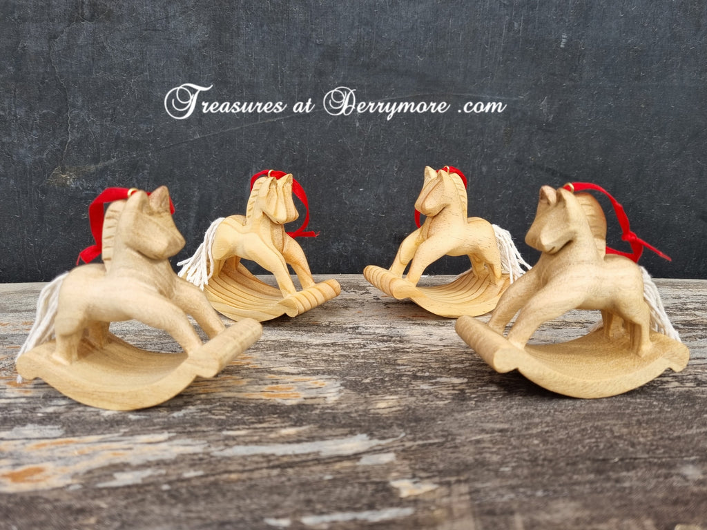 Hand carved wooden Christmas decorations. Rocking horses cut from pine decorated with white string tail, red ribbon hanger.