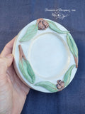 Hand carved round wooden dish with relief carved & green painted Eucalyptus leaves & brown gumnuts around the rim of dish 