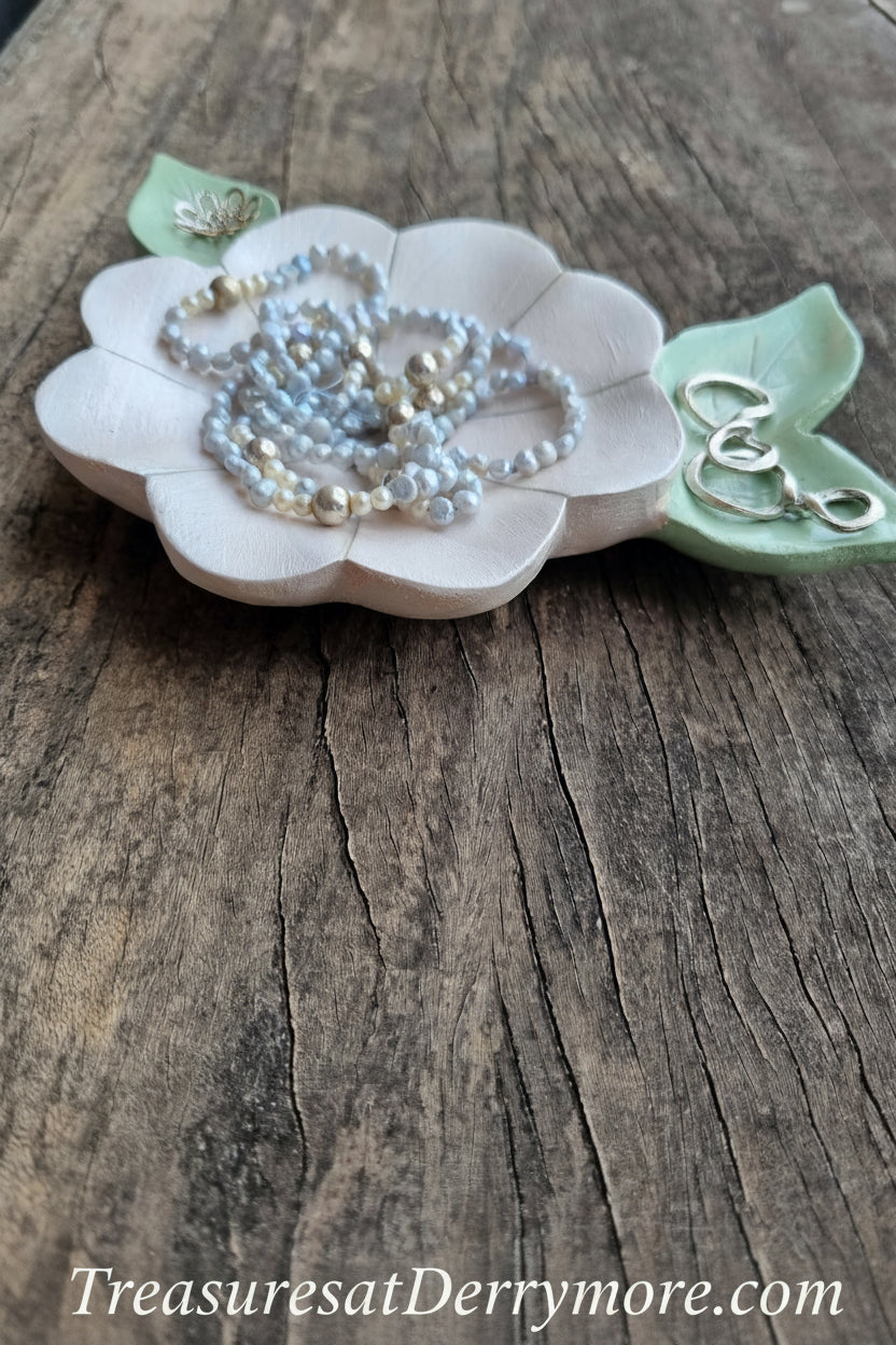 Hand carved and painted white flower shaped dish with green carved leaves with jewellery 