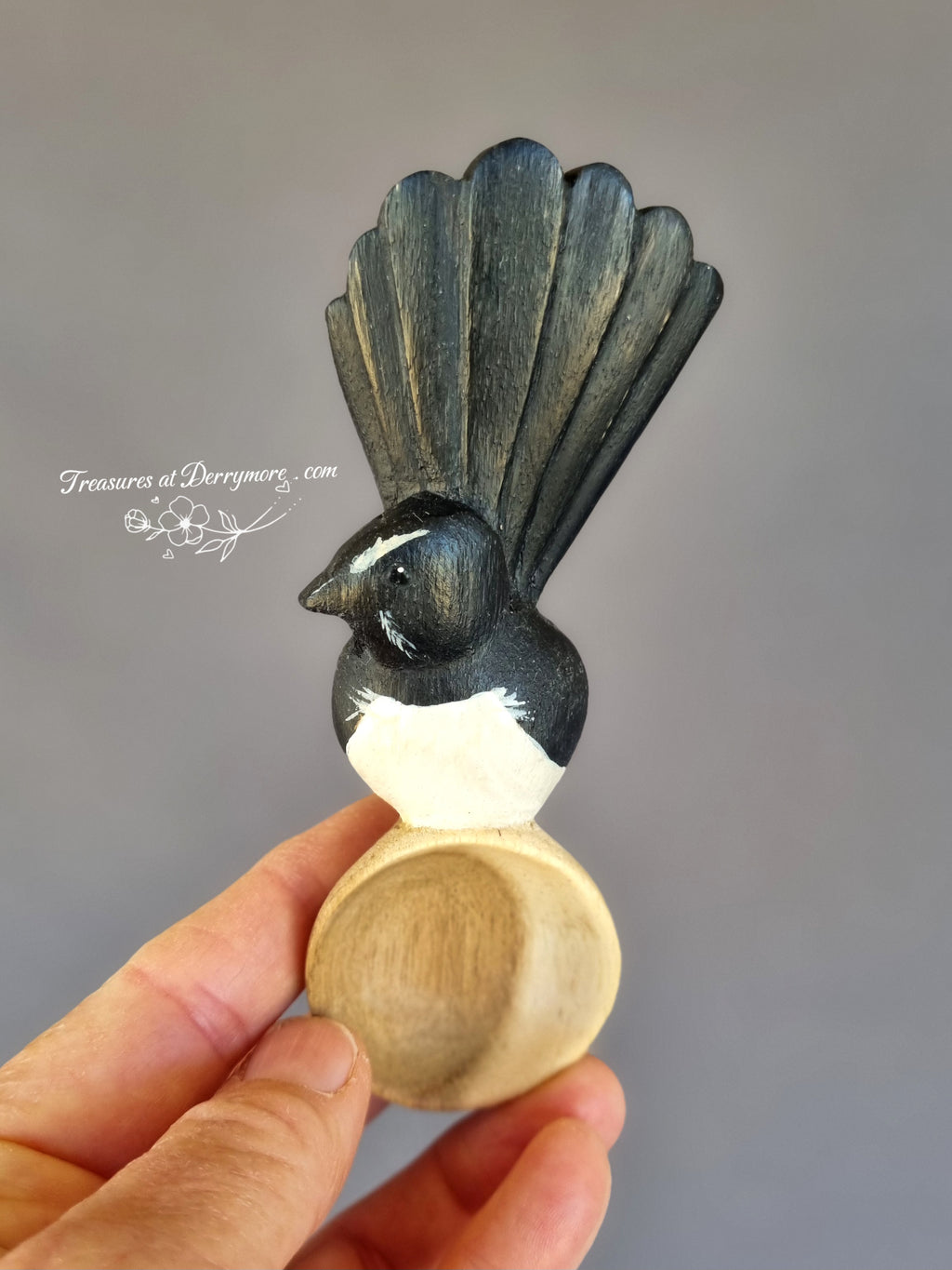 Hand carved and painted wooden Williewagtail spoon held in hand