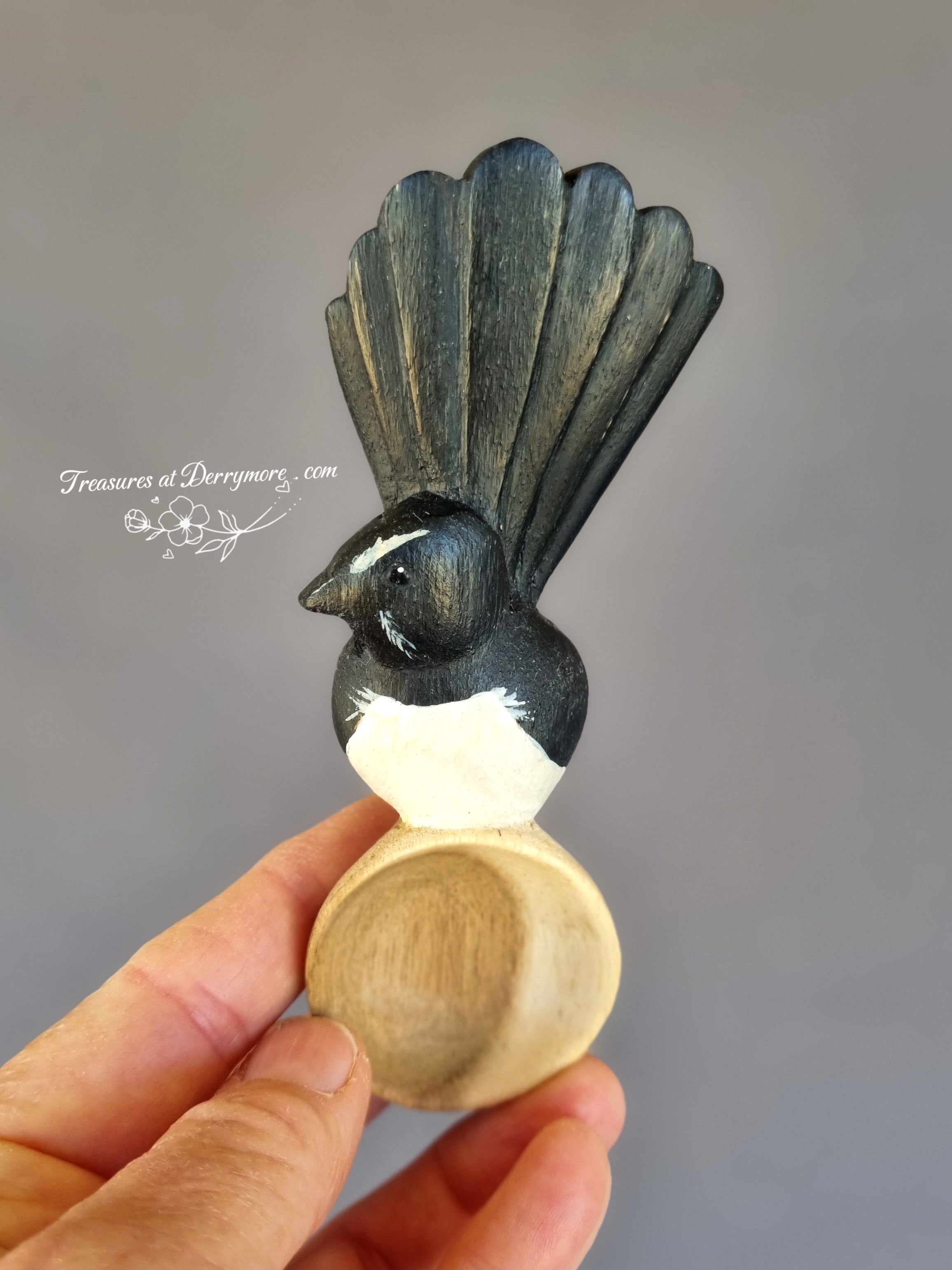 Hand carved and painted wooden Williewagtail spoon held in hand